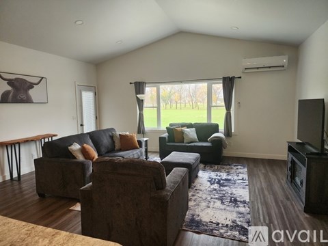 A living room with a couch, chair, and television.