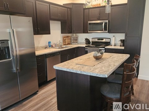 A kitchen with a granite countertop and stainless steel appliances.