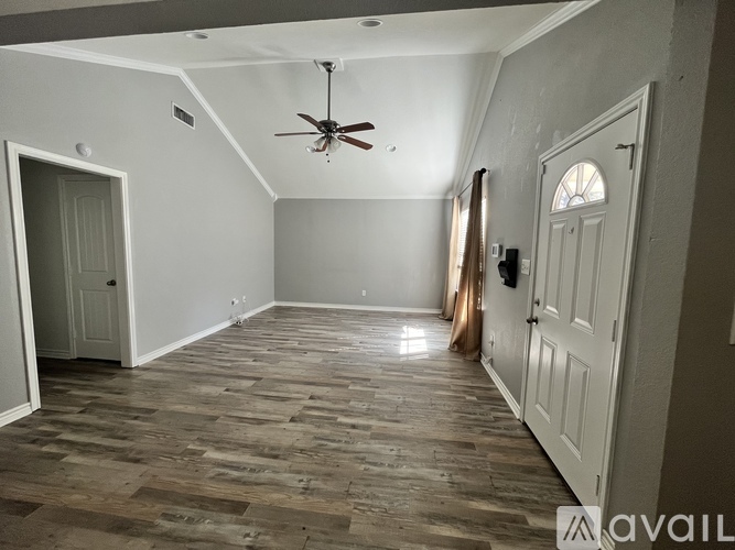 A room with wooden flooring and a ceiling fan.