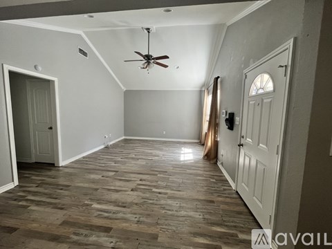 A room with wooden flooring and a ceiling fan.