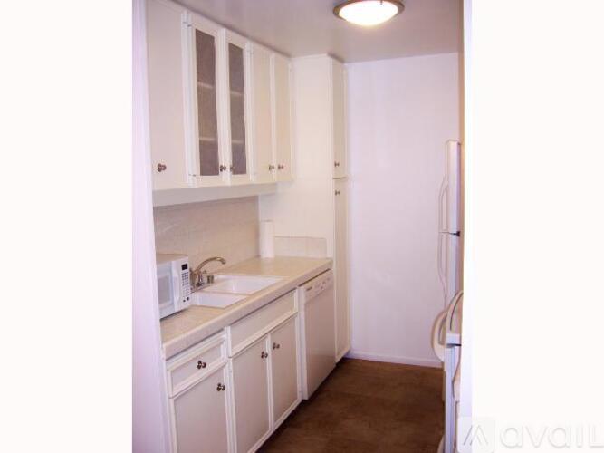 A kitchen with white cabinets and appliances.