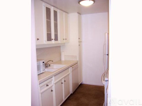 A kitchen with white cabinets and appliances.