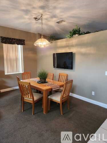 A dining room with a table and chairs.
