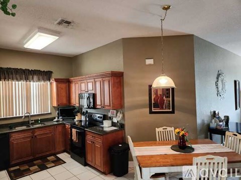 A kitchen with brown cabinets and a black stove top oven.