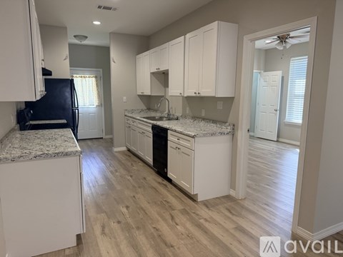 A kitchen with white cabinets and a granite countertop.