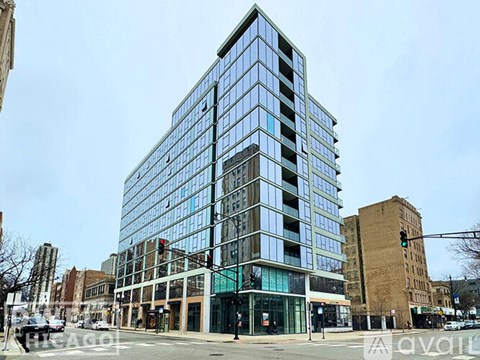 A modern glass building stands tall in an urban setting.