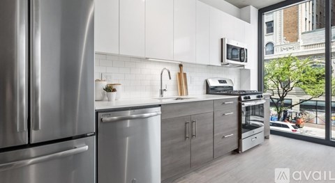 A modern kitchen with stainless steel appliances and white cabinets.