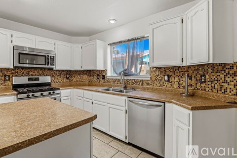 A kitchen with white cabinets and a granite countertop.