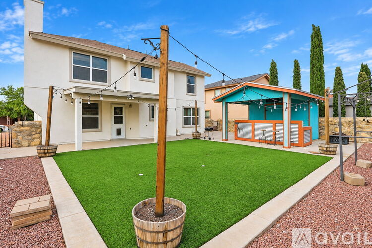 A house with a white exterior and a blue shed in the backyard.