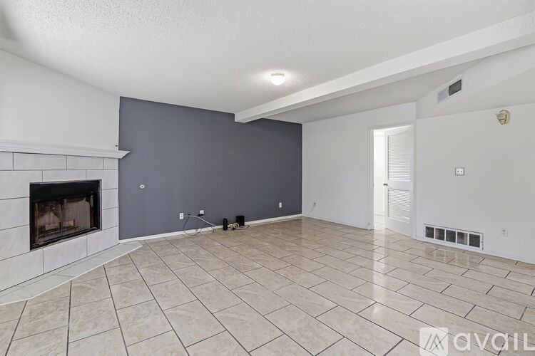 A spacious living room with a fireplace and tiled flooring.