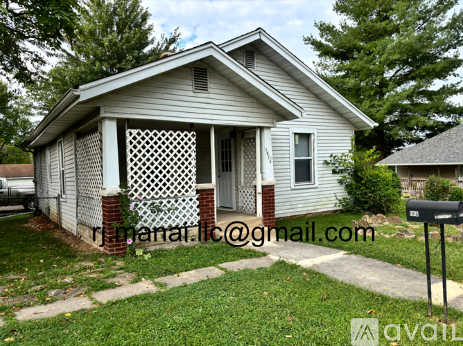 A small house with a porch and a mailbox in front.