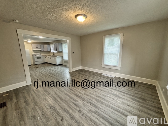A room with a kitchen visible through the doorway.