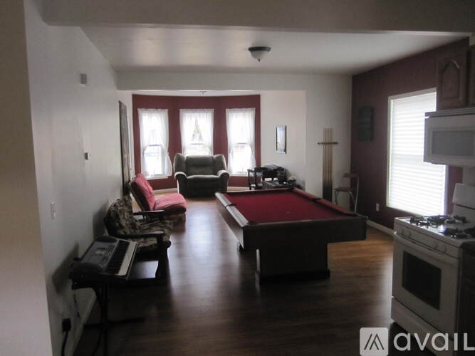 A living room with a pool table and a couch.