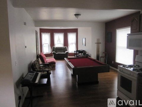 A living room with a pool table and a couch.