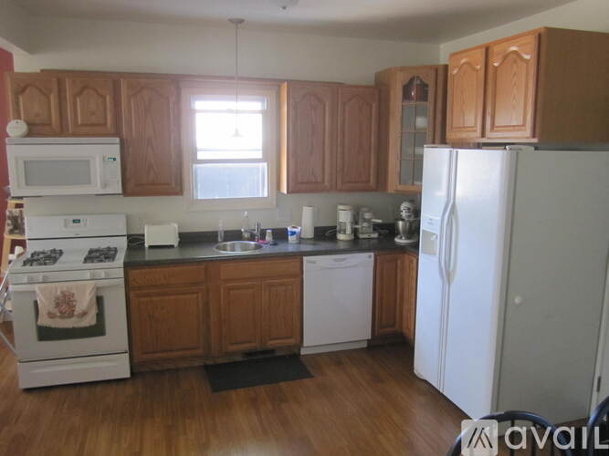 A kitchen with wooden cabinets and white appliances.