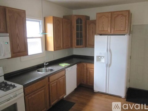 A kitchen with wooden cabinets and a white refrigerator.