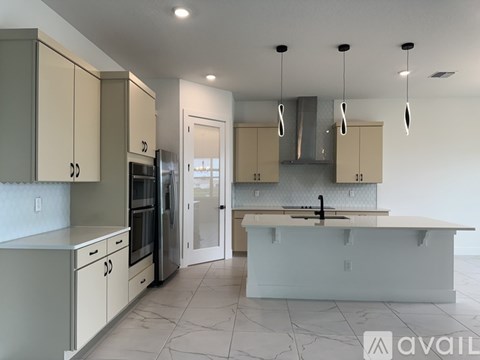 A kitchen with a white countertop and beige cabinets.