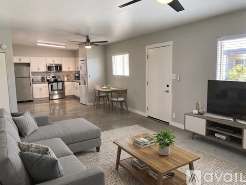 A living room with a grey couch and a wooden coffee table.
