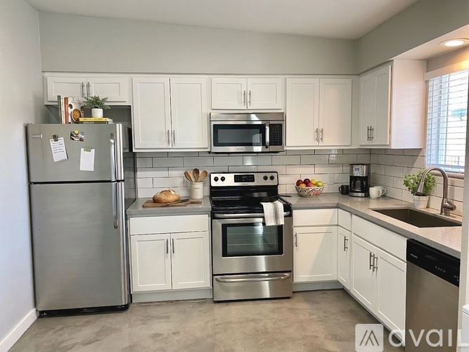 A kitchen with white cabinets and stainless steel appliances.