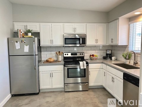 A kitchen with white cabinets and stainless steel appliances.