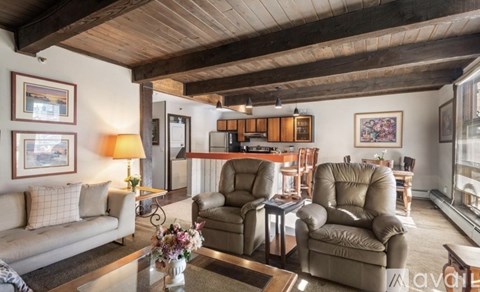 A living room with a couch, two chairs, and a coffee table.