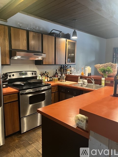 A kitchen with wooden cabinets and a stainless steel oven.