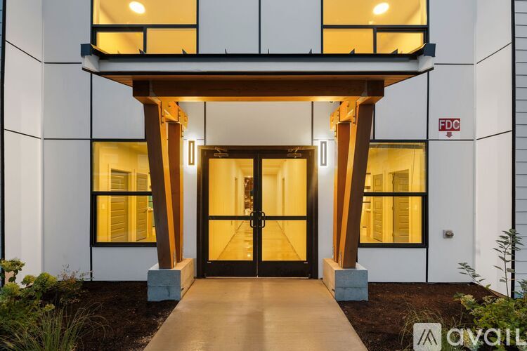 A modern house entrance with a glass door and a wooden overhang.