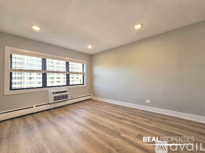 A room with a window and a wall-mounted air conditioner unit.