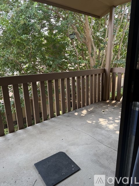 A balcony with a wooden railing and a concrete floor.