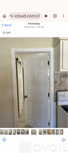 A white door is open in a room with a tiled wall.