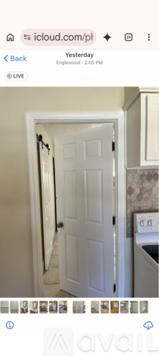 A white door is open in a room with a tiled wall.