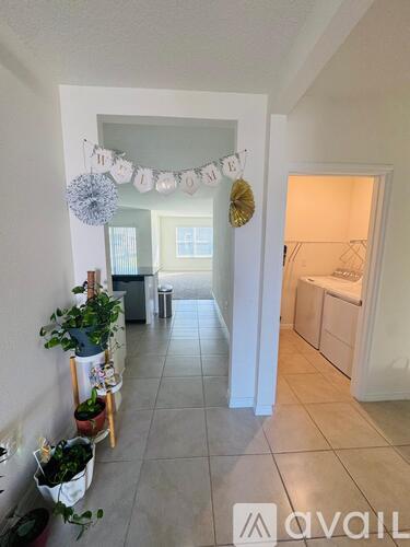 A hallway with a banner that says "home" and a laundry room in the background.