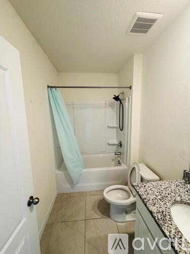 A bathroom with a toilet, sink, and bathtub.