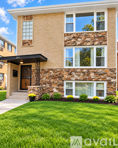A house with a stone wall and a black awning.