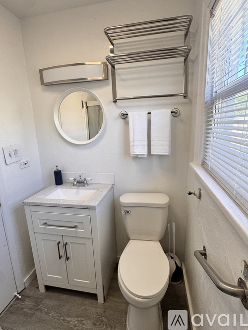 A bathroom with a toilet, sink, and towel rack.
