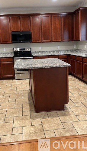 A kitchen with brown cabinets and a granite countertop.