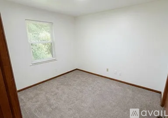 A room with a window and carpeted floor.