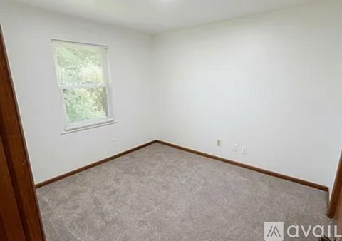 A room with a window and carpeted floor.