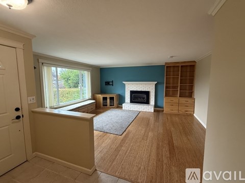 A living room with a fireplace and a rug on the floor.