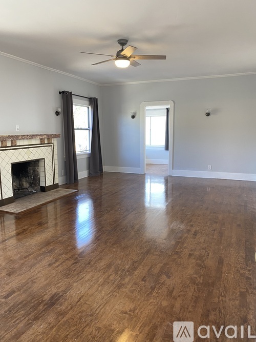 A room with a fireplace and wood flooring.