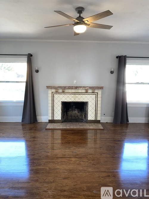 A living room with a fireplace and a fan.