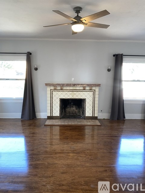A living room with a fireplace and a fan.