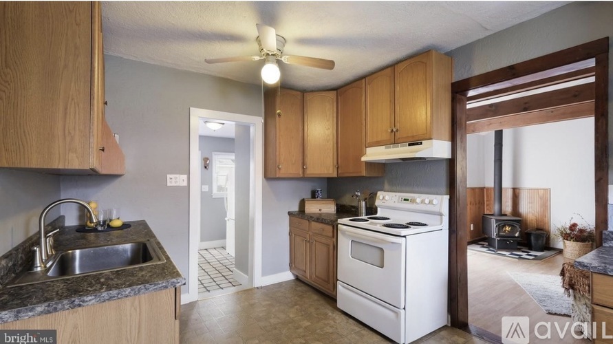A kitchen with wooden cabinets and a white stove top oven.