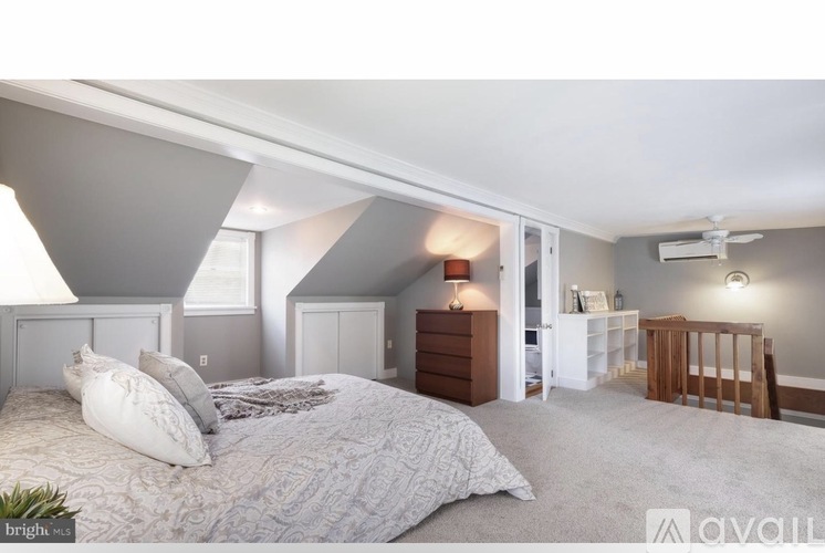 A bedroom with a large bed and a crib in the corner.