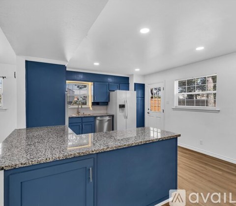 A kitchen with blue cabinets and a granite countertop.