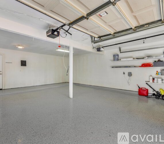 A spacious garage with a white floor and a white pillar in the middle.