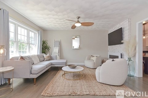 A living room with a grey sofa, a white armchair, and a coffee table.