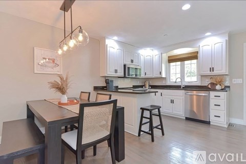 A kitchen with a dining table and chairs.
