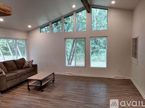 A living room with a couch, coffee table, and large windows.