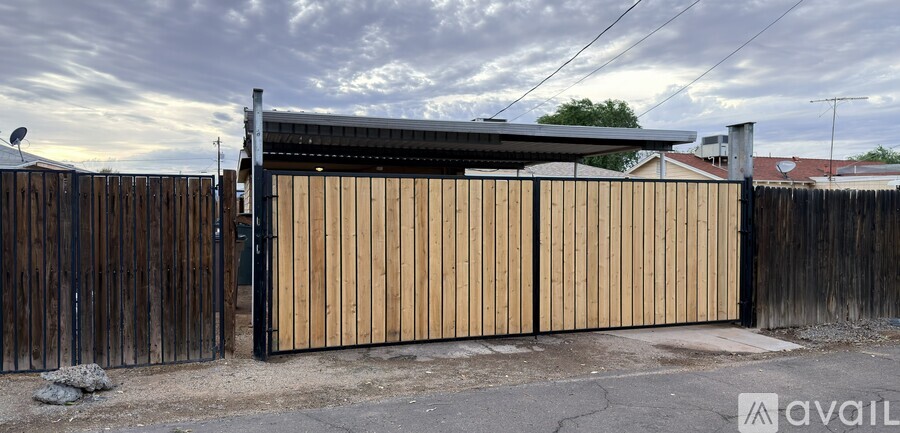 A wooden gate is closed with a metal latch.